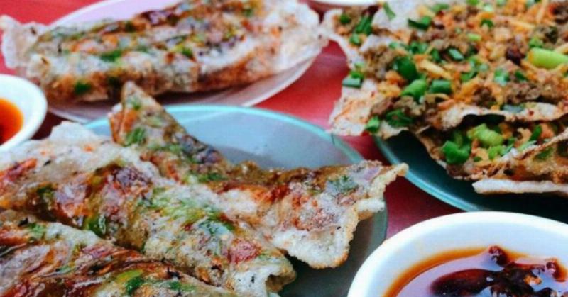 Chiếc bánh tráng sai gon nuong vang ruom voi nhieu topping hap dan dang duoc nuong tren bep than